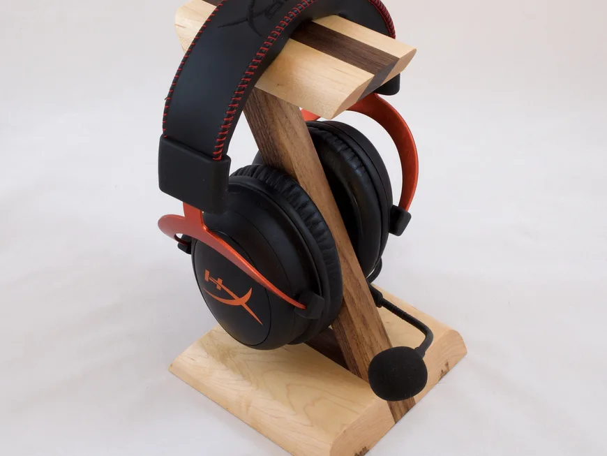 A Z-shaped maple and walnut headphone stand with headphones